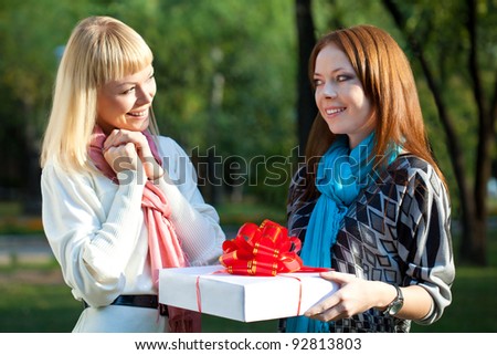 two sisters with gift in the summer park