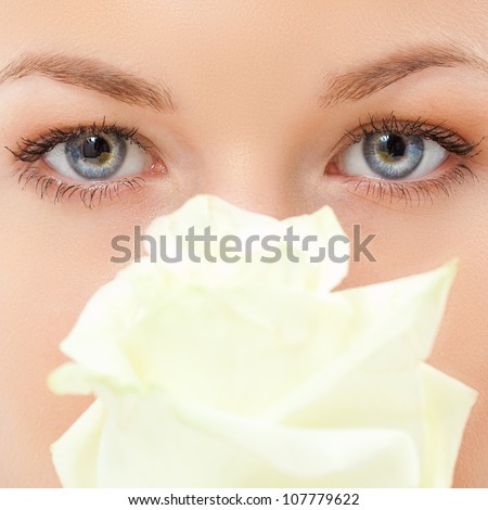 closeup woman eyes with white rose flower