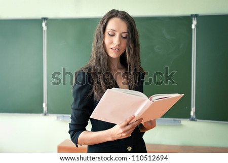 woman standing over green chalkboard at the classroom