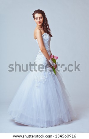 beautiful bride holding bouquet studio full length portrait, toned image