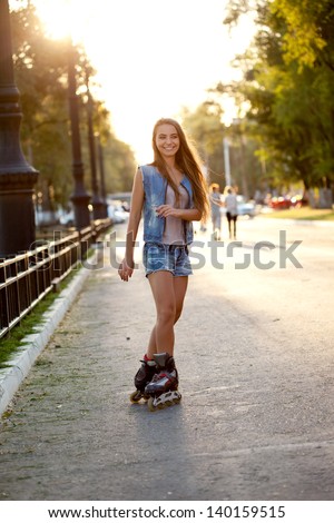 happy smiling woman skating outdoors  during sunset
