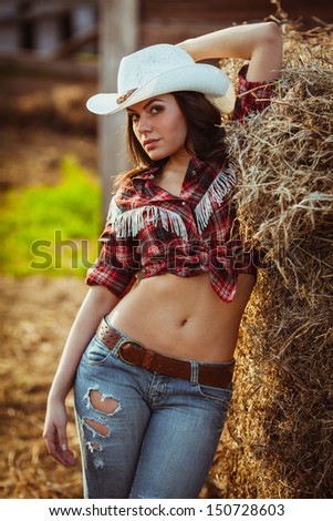 beautiful cowgirl style model posing on farmland
