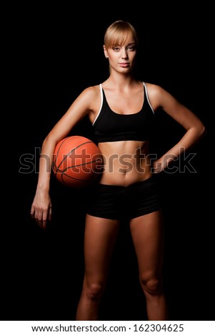 woman standing with basketball over black background