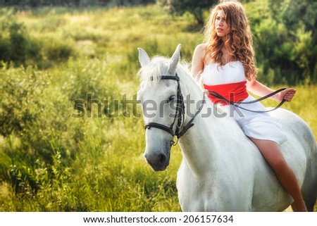 Beautiful women wearing white dress riding on white horse