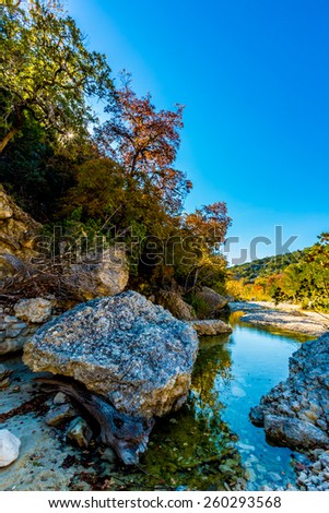 Big Boulders and Bright Beautiful Fall Foliage on Maple Trees on a little creek in Lost Maples State Park, Texas
