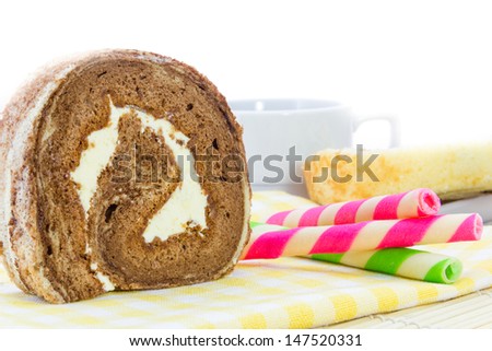 Chocolate roll and Wafer rolls  on yellow tablecloth