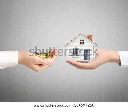 holding house representing home ownership and the Real Estate business