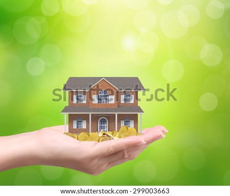 Businessman holding home model and coins ,Loan concept