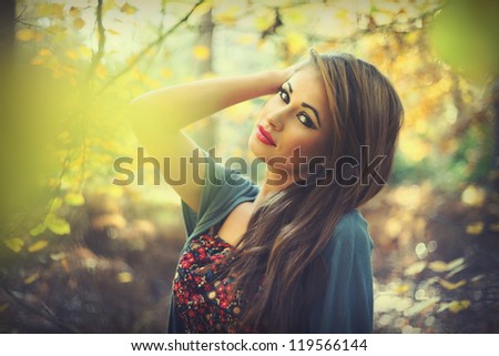Beautiful woman in woods in autumn. Fashion look.