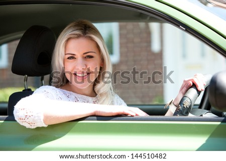 Car woman happy in small green car. Attractive young woman driving on road trip on sunny summer day