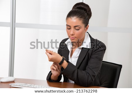 Attractive businesswoman looking at watch