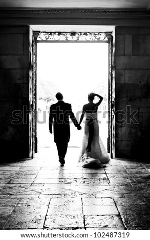 Bride and Groom walking through large doorway