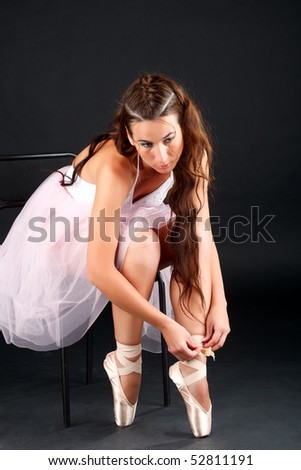 Young ballerina before performance, on a black background