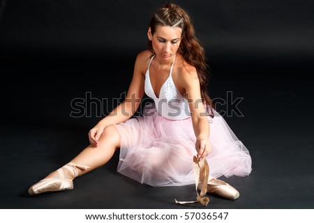 Young ballerina after the performance, on a black background