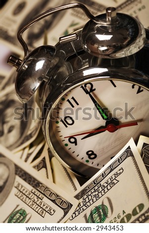 close up of the oldfashioned alarm clock with money
