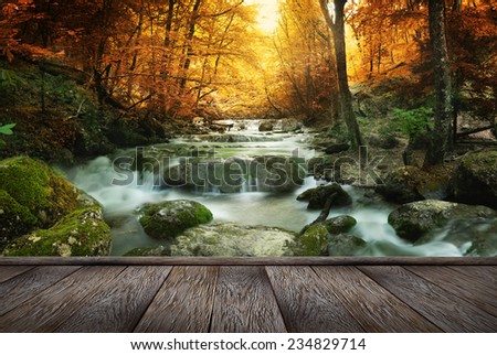 Autumn creek woods with yellow trees foliage and rocks in forest mountain and wood pier