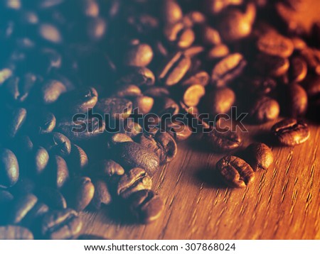 Fresh roasted coffee beans on wooden board.Filtered image: cool cross processed vintage effect.