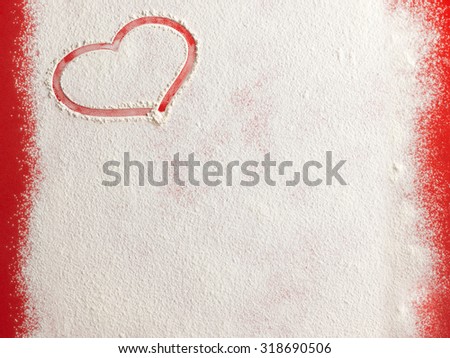 Valentine love red heart shape in snow on red background. Closeup.Christmas card.
