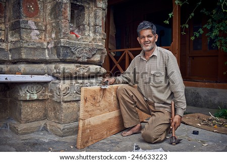 Naggar, INDIA - JULY 17: Indian carpenter made a new door. Posing for photography. July 17, 2013 in Naggar, Kullu Valley, Himachal Pradesh, India.