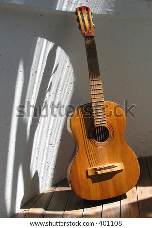 Old spanish guitar made in russia over the white wall