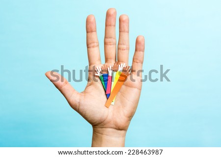 Hand up showing group of diverse multicolors paper hands on blue background. Multiracial concept.