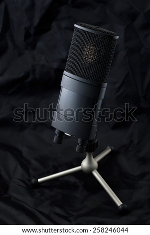 Professional microphone on a stand with soft black background