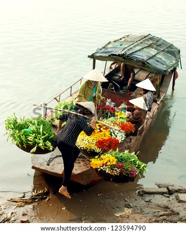 women selling flowers on a boat in the early morning