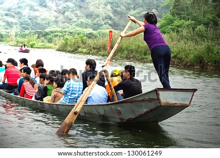 HANOI, VIETNAM-MARCH 2: Woman rowing boat carrying people to the HUONG Pagoda. March 2, 2013 in HANOI, VIETNAM. HUONG Pagoda Festival is the largest festival in the tradition of Vietnam