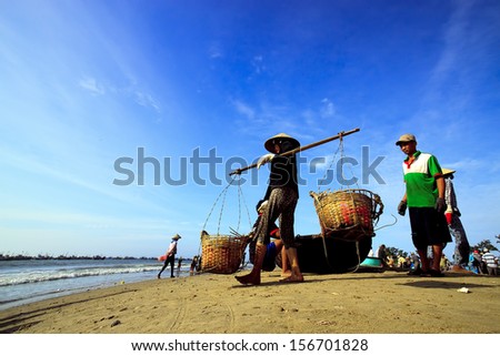 HALONG, VIETNAM - AUGUST 14: Fishermen sort out their catch on the shore and sell fish to dealers, August 14, 2013, HaLong, Vietnam