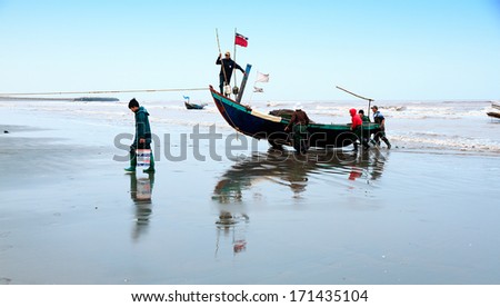 NAM DINH, VIETNAM - JANUARY 12: A lot of fishers sort out their catch on the shore and sell fish to dealers, January 12, 2013, NamDinh, Vietnam