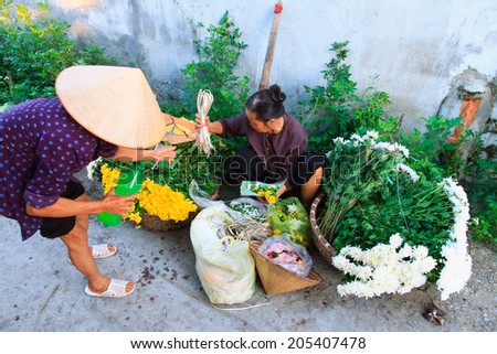 NAMDINH, VIETNAM July 10. 2014 : Unidentified flower vendor at the flower small market in Namdinh, Vietnam. This is a small market for retail florists and street vendors.
