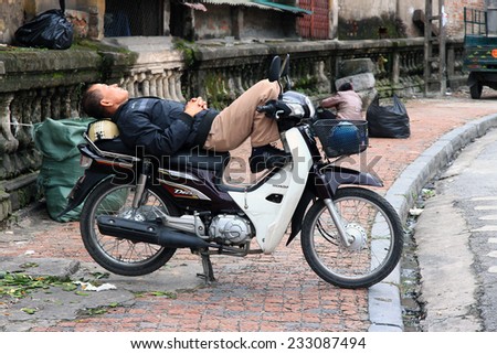 Hanoi, Vietnam - Nov 08, 2014: a driver passenger motorcycle enlist sleep while waiting for customers in Hanoi, Vietnam.