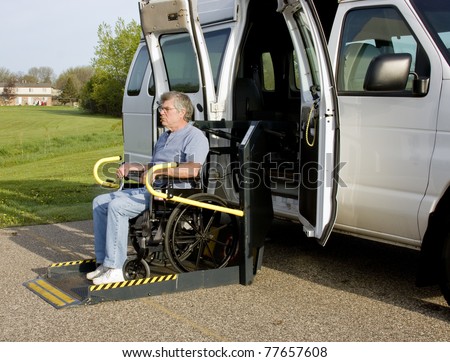 handicap van with a man in a wheelchair on a lift