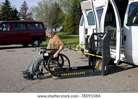 handicapped person backing his wheelchair onto a lift van