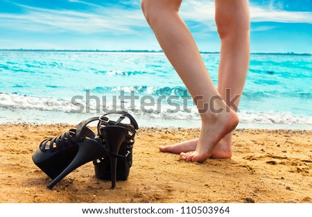 Girls stands on a beach barefooted