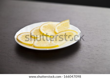 The lemon on a plate costs on a table waiting for tea drinking