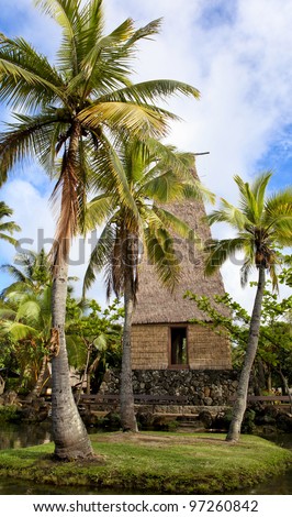 A traditional Hawaiian hut and palm trees in Polynesian Cultural Center Oahu Hawaii