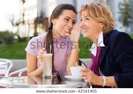 Daughter and Mother chatting in Cafe outdoors.