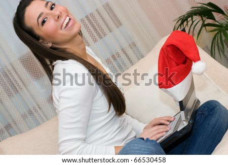 Beautiful young woman sitting on the sofa and on-line shopping.