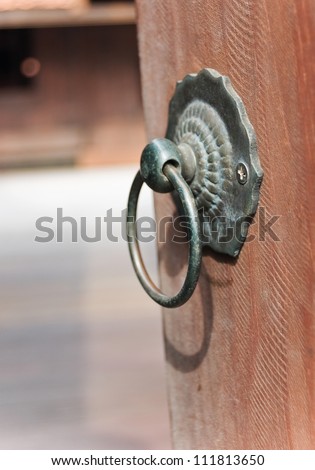 Old rusty iron door handle on wood door