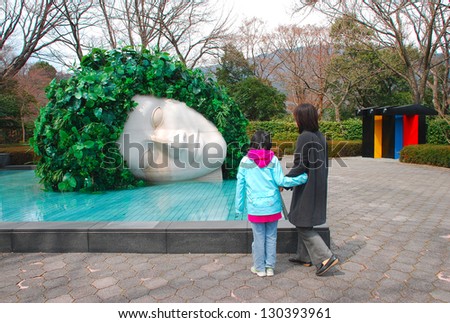 KANAGAWA,JAPAN-MARCH 31:women looking at sculpture of head in pool in the Hakone Open-Air Museum on March 31,2010.the Hakone Open-Air Museum opened in 1969 as the first open-air art museum in Japan.