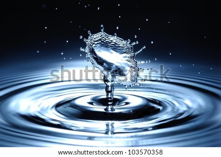 A small water drop fall on water surface and bounce back, colliding with the second one to form a beautiful shaped splash.