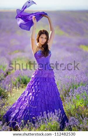 Portrait of beautiful romantic woman in fairy field of lavender