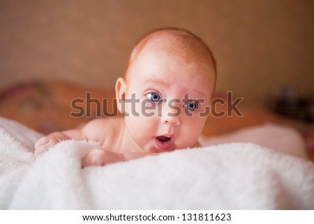 Portrait of cute newborn baby with a funny expression on his face