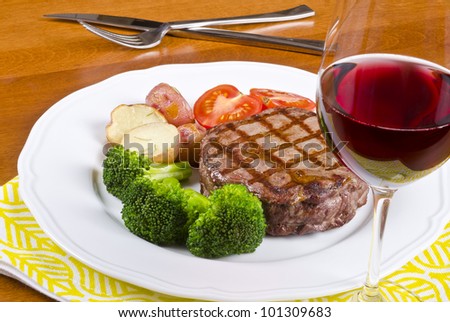 Barbecued Rib Eye Steak Served with Vegetables and a Glass of Red Wine