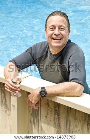 Man in a Wet Suit Drinking White Wine in a Swimming Pool