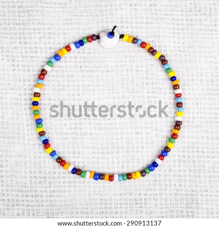Colorful Necklace Made with Small Plastic Beads Displayed as a Circle