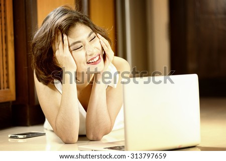 Asia office woman lying on floor with open laptop at home, vintage effect