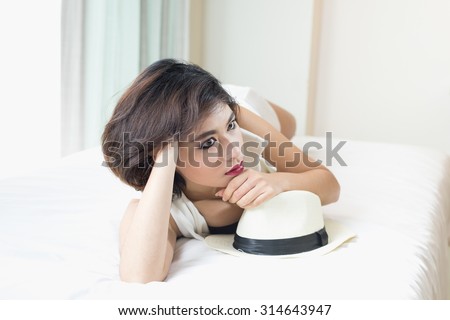 Asia woman black bikini posing on white bed