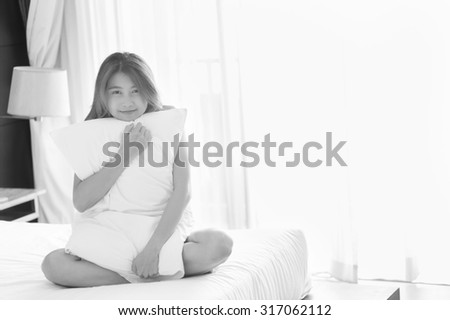 asia young sexy woman in white towel hug Pillow sit on bed in bedroom at home, black and white